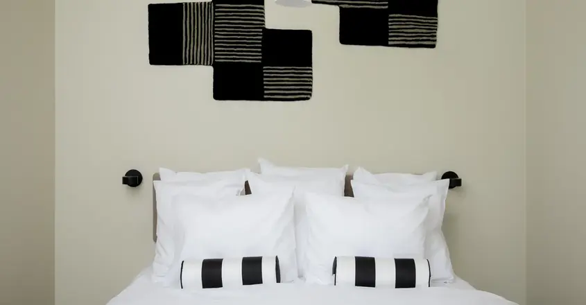 a bed with pillows and a lamp