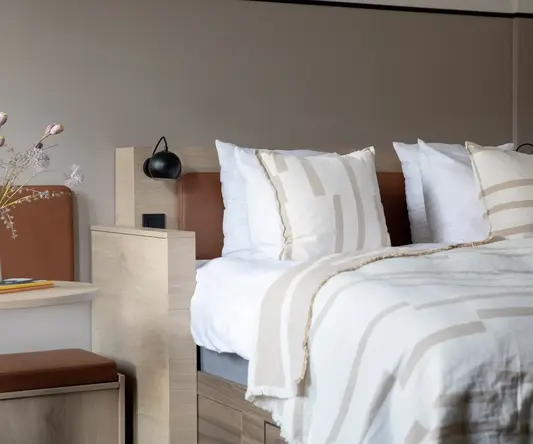 a bed with pillows and a lamp