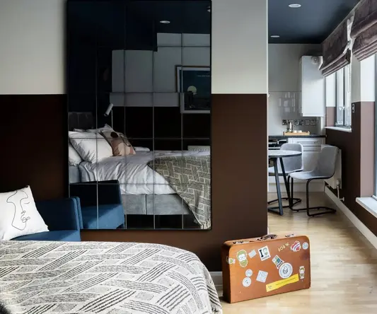 a bedroom with a mirror and a bed