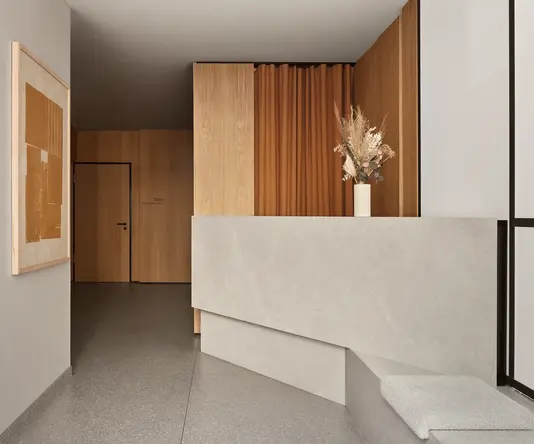 a hallway with a stone counter and a vase of flowers