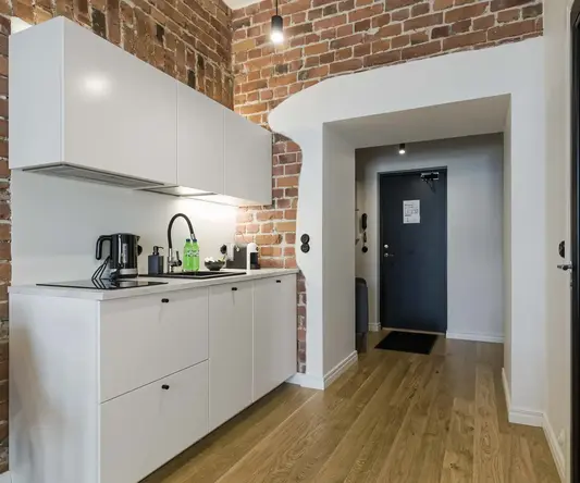 a kitchen with brick walls and a door