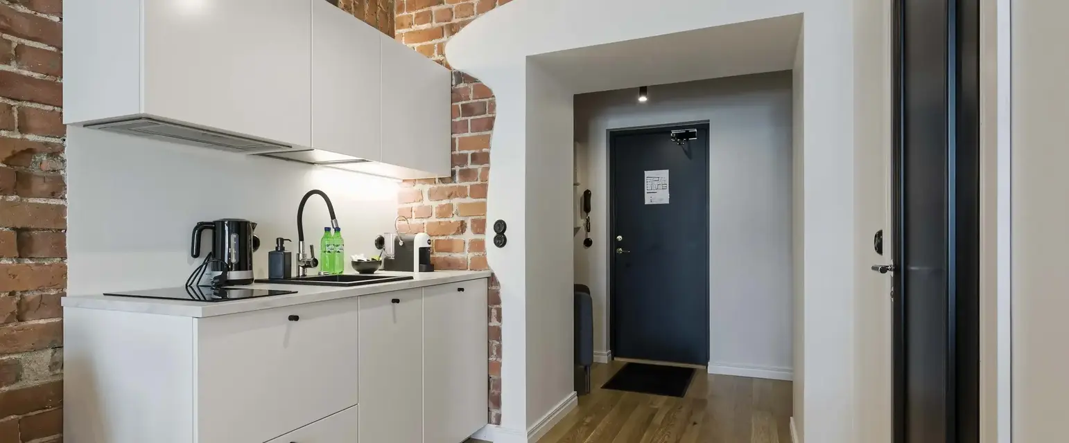 a kitchen with brick walls and a door