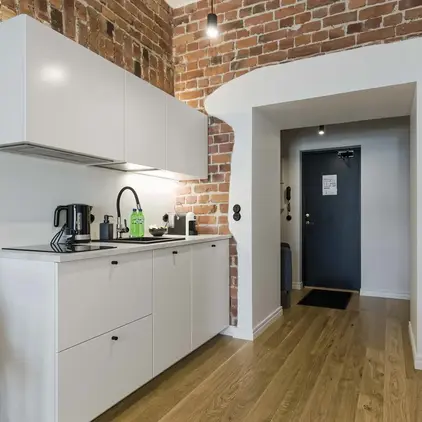 a kitchen with brick walls and a door