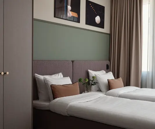 a bed with pillows and a vase of flowers on it