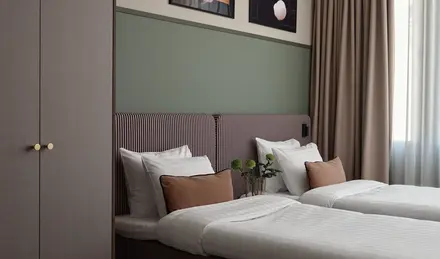 a bed with pillows and a vase of flowers on it