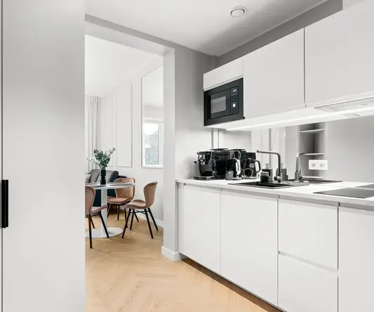 a kitchen with white cabinets and a table