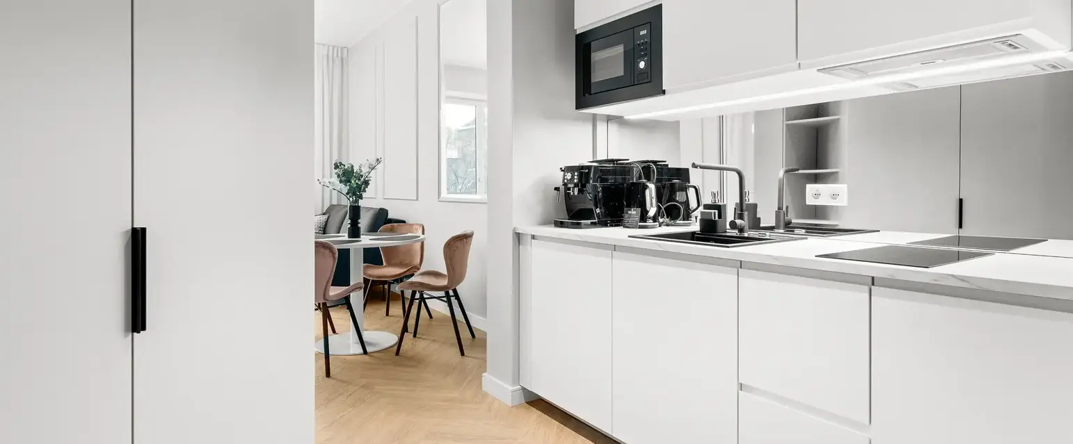 a kitchen with white cabinets and a table