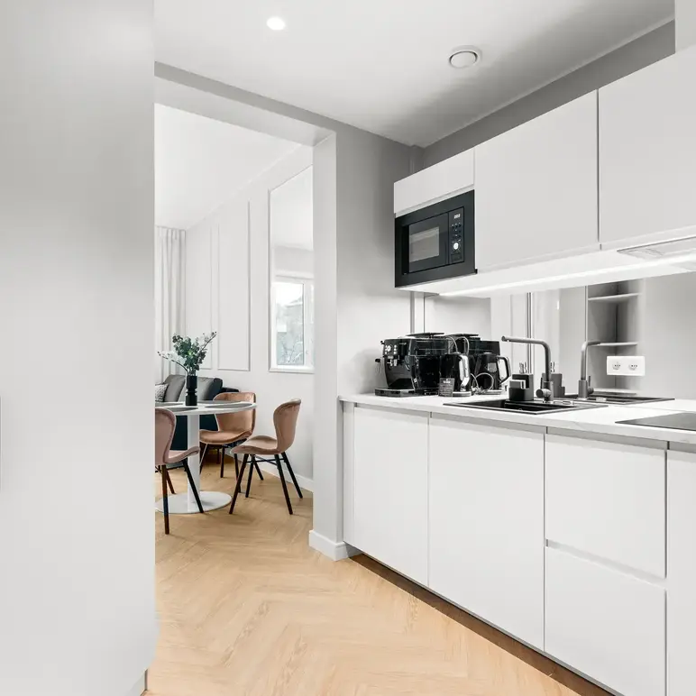 a kitchen with white cabinets and a table