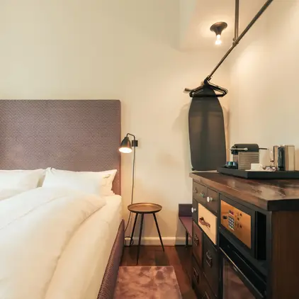 a bed with a white blanket and a brown headboard