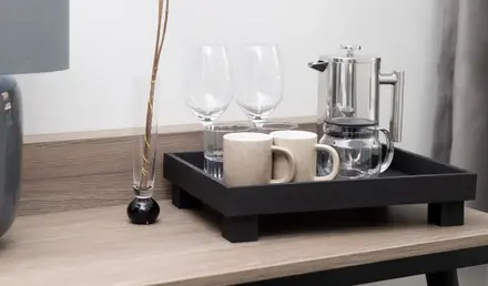 a tray with glasses and a vase with flowers on it