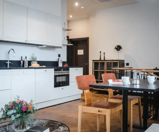 a kitchen with white cabinets and a table