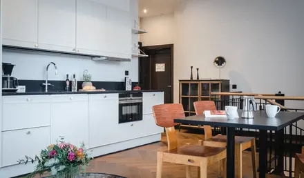 a kitchen with white cabinets and a table