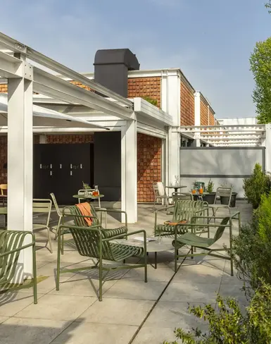 a patio with chairs and trees