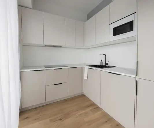 a kitchen with white cabinets and a wood floor