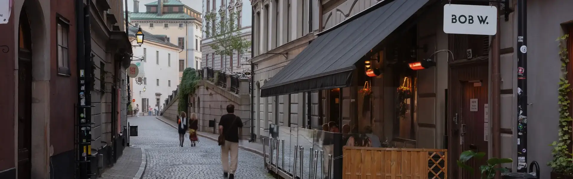 a man walking down a cobblestone street