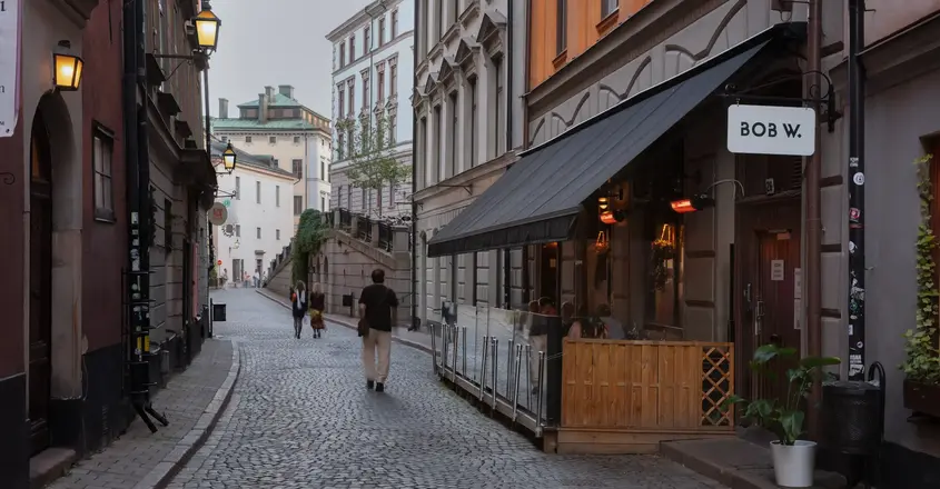 a man walking down a cobblestone street