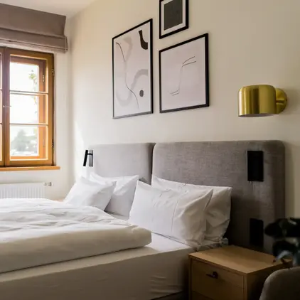 a bed with pillows and a lamp in a room