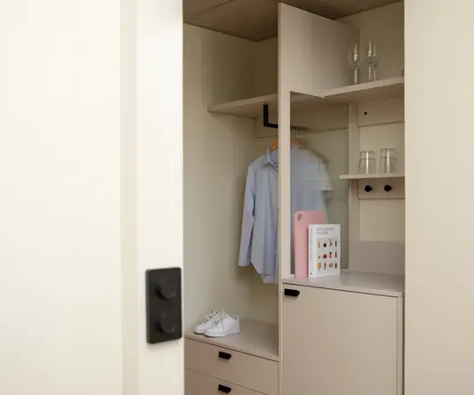 a closet with a white cabinet and shelves