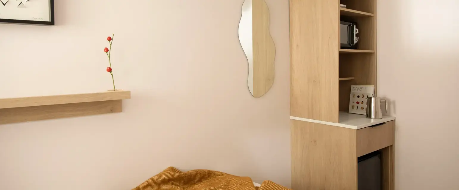 a room with a mirror and a bed