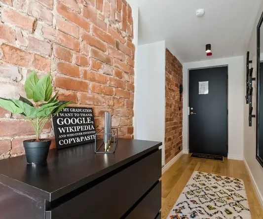 a room with a brick wall and a dresser