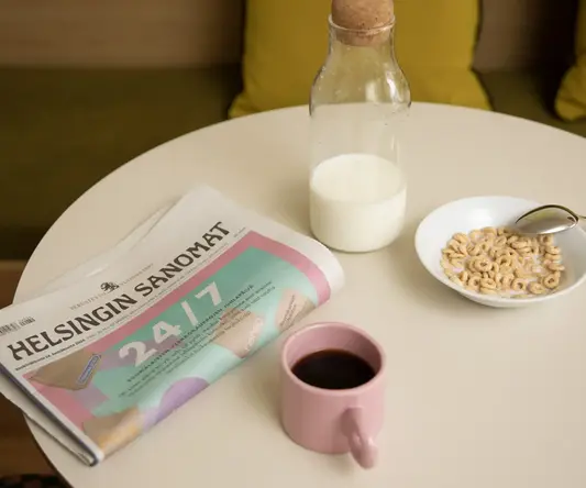 a newspaper and a cup of coffee on a table