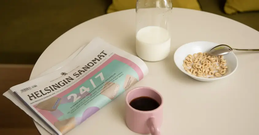 a newspaper and a cup of coffee on a table