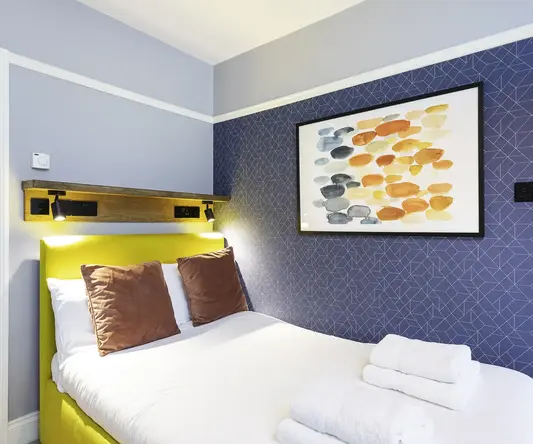 a bed with towels and a painting on the wall