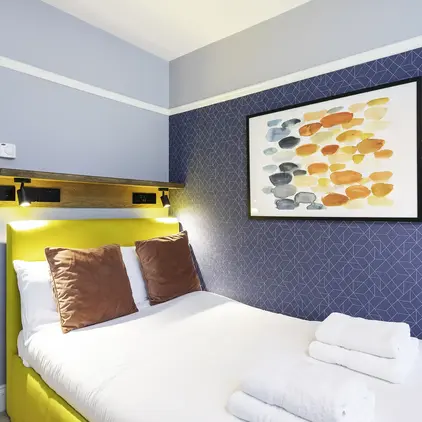 a bed with towels and a painting on the wall