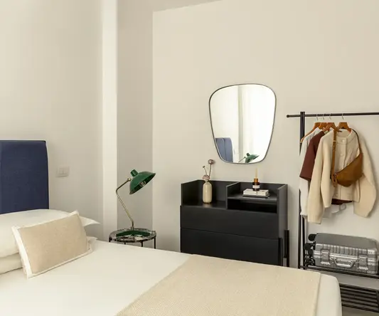 a room with a mirror and a bed