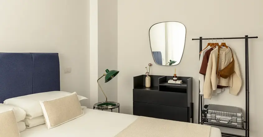 a room with a mirror and a bed