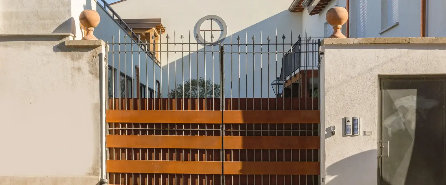 a gated driveway with a house behind it
