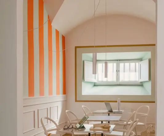 a room with white chairs and tables