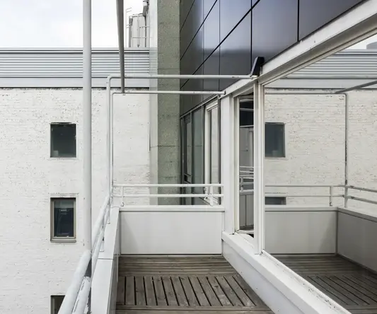 a balcony with a white railing and a white wall