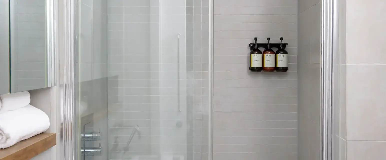 a shower with glass doors and a bathtub