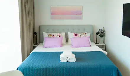 a bed with a blue blanket and towels on it