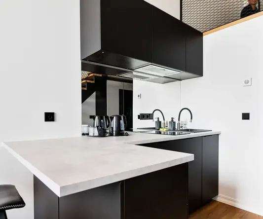a kitchen with black cabinets and white walls