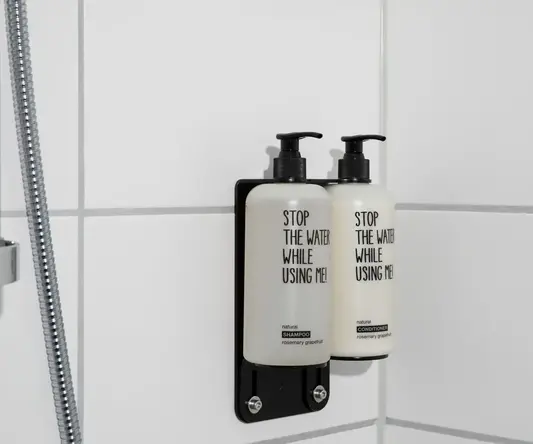 a couple of white bottles on a white tile wall