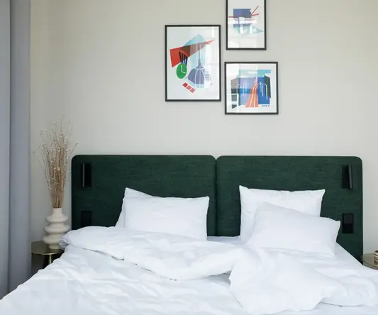 a bed with white sheets and pillows