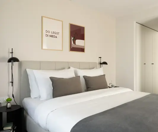 a bed with pillows and a lamp