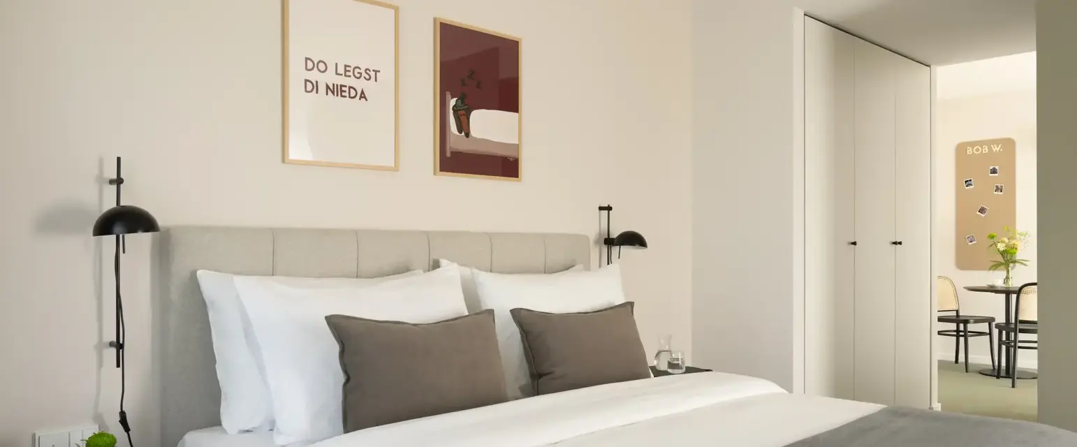 a bed with pillows and a lamp