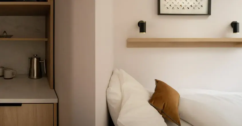 a bed with pillows and a shelf