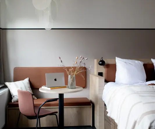a room with a bed and a laptop on a table