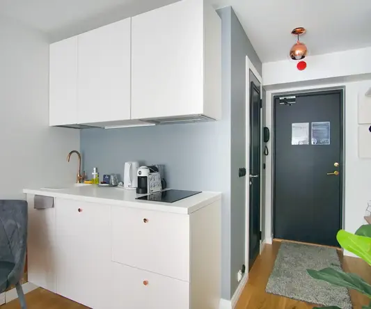 a kitchen with white cabinets and a chair