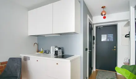 a kitchen with white cabinets and a chair
