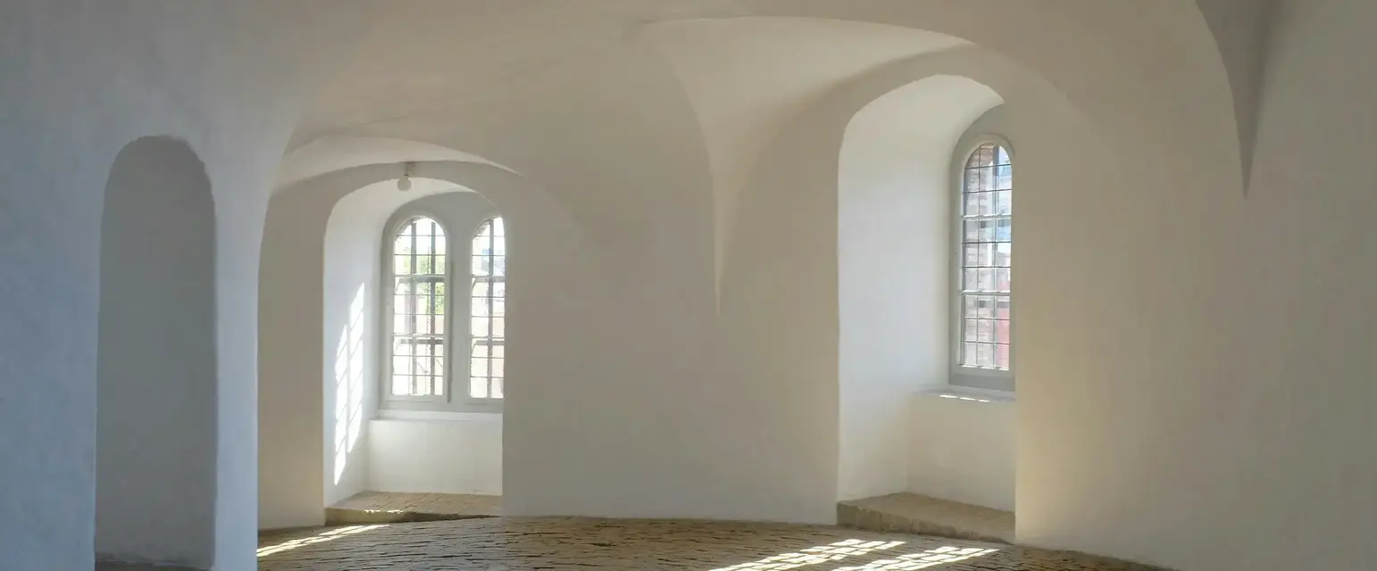 a room with arched windows and brick floor