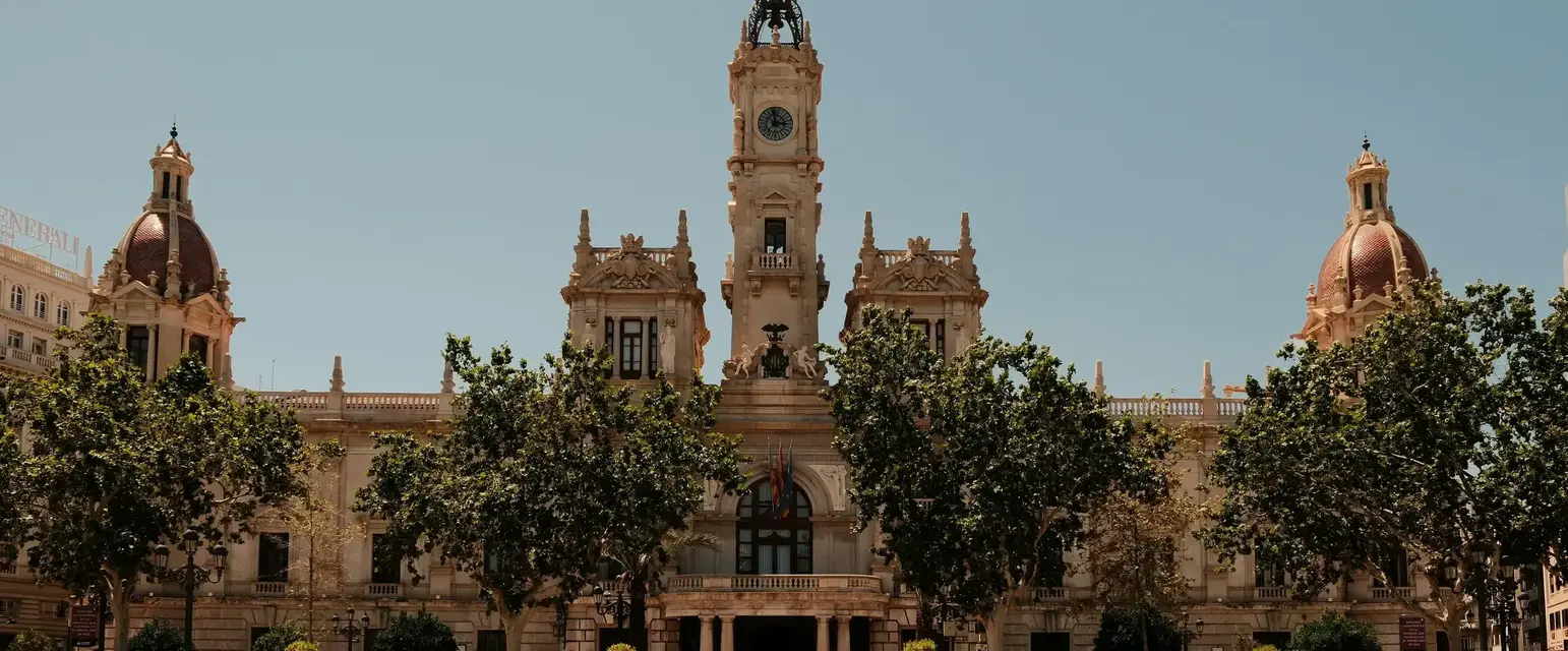 a large building with a clock tower and trees