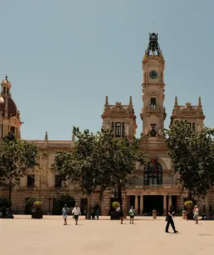 a large building with a clock tower and trees