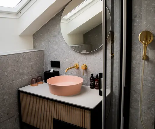 a sink with a round mirror and a shower