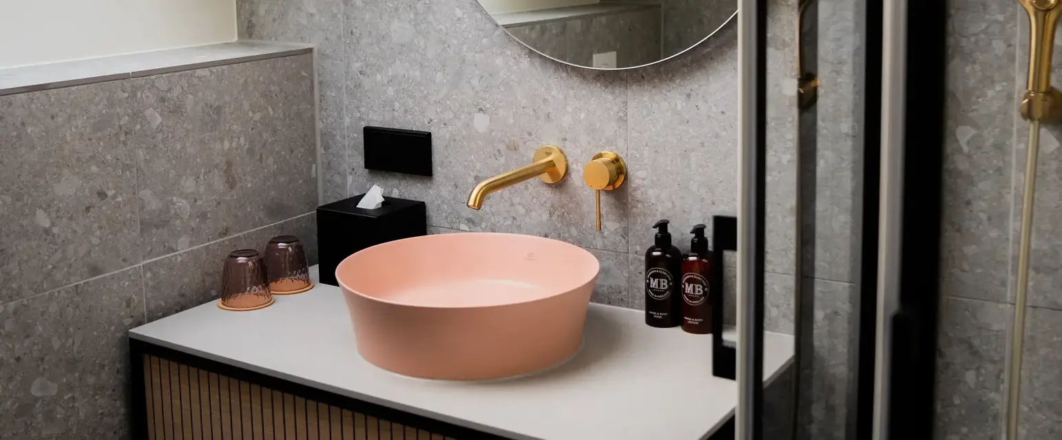 a sink with a round mirror and a shower