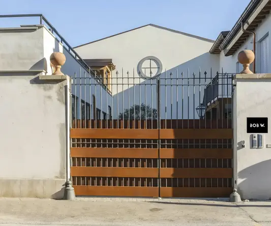 a gated driveway with a house behind it